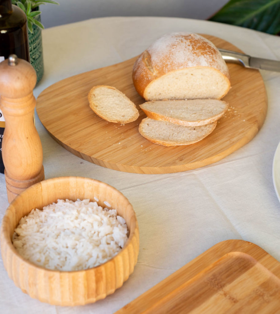 bowl de bambu com arroz em mesa posta com pão para decoração criativa