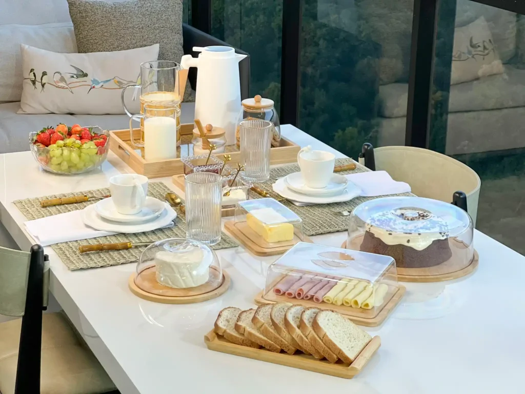 Mesa posta para café da manhã com alimentos e utensílios de cozinha.